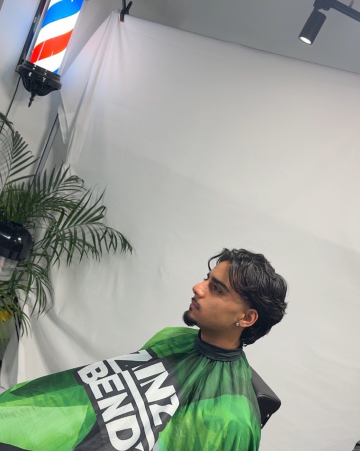 Textured fade finished at ZB Studioz, barber pole in the background