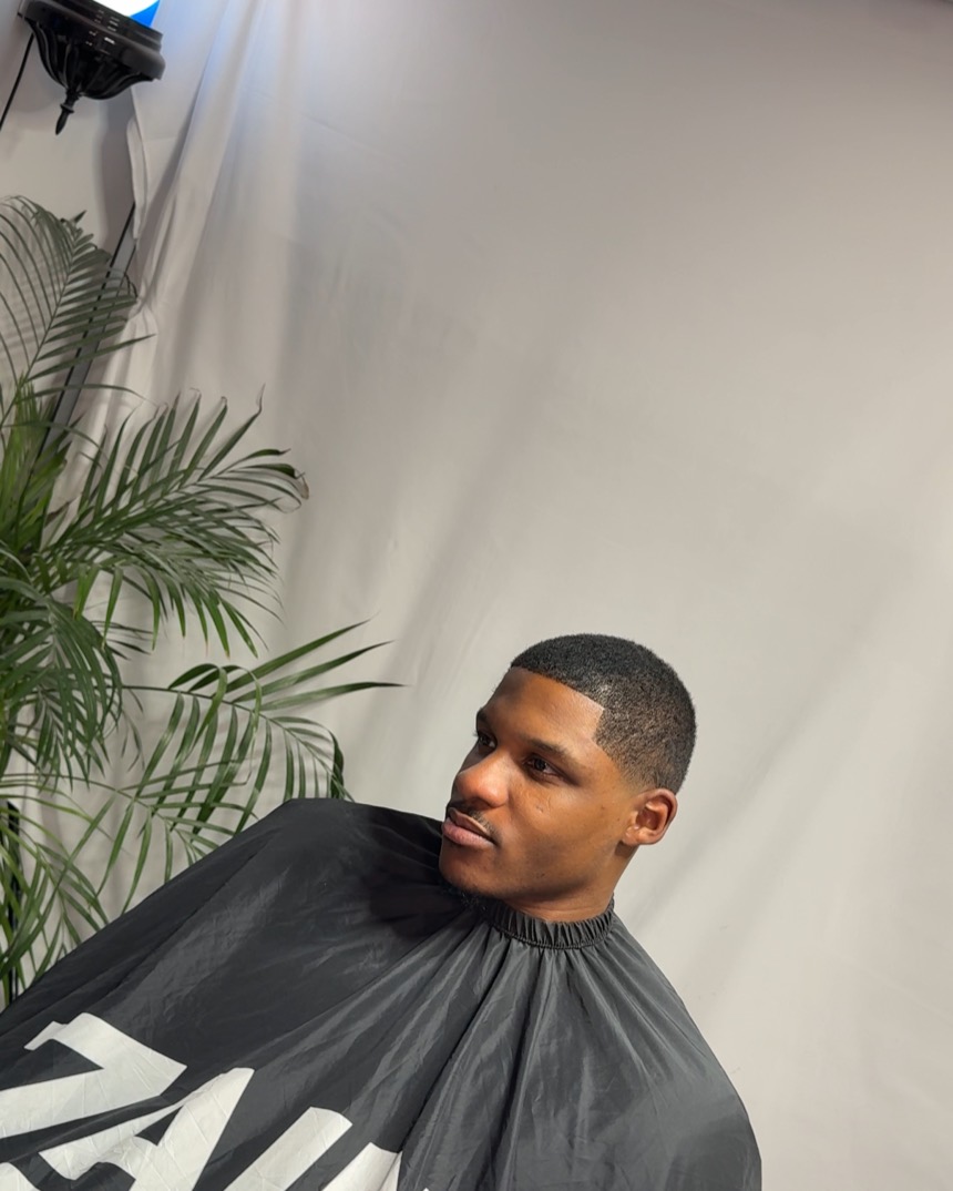 A close skin fade finished against the studio backdrop